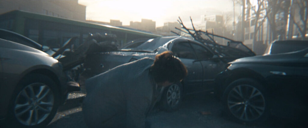 Min-sung searches among wrecked cars in Concrete Utopia