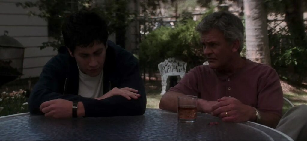 Donnie and his father sit at a glass patio table in Donnie Darko.