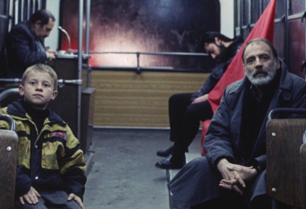 Alexandre and a young Albanian boy sit together on a bus in Eternity and a Day