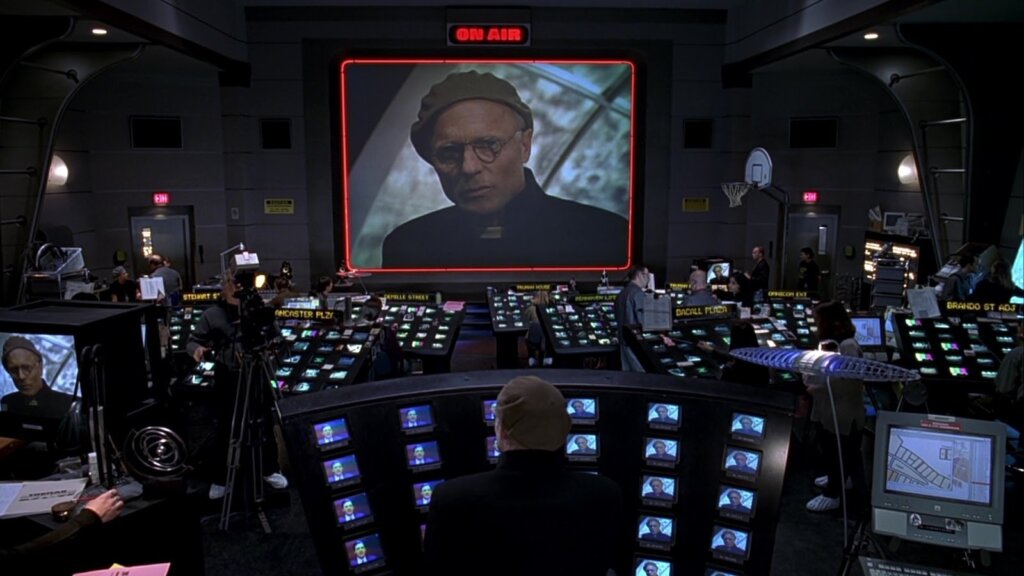 Christof watches Truman from the program’s surveillance-filled control room in The Truman Show.