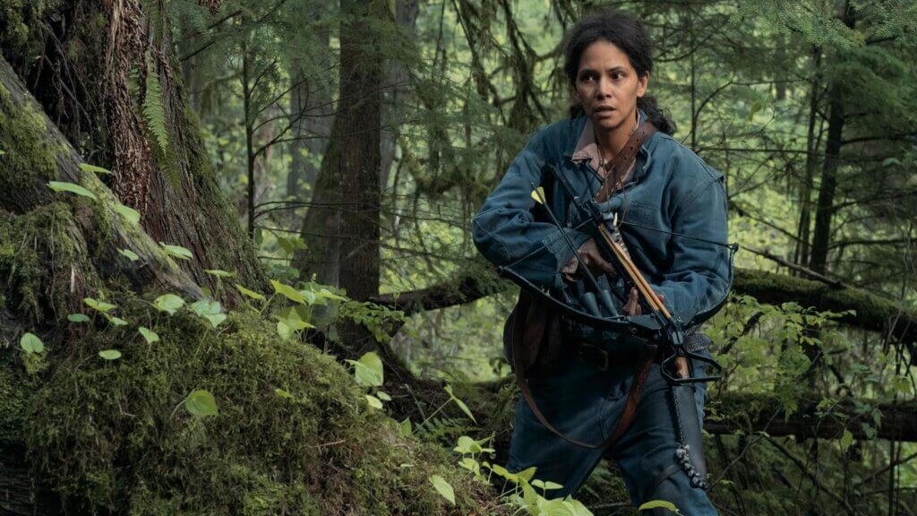 Momma carries a crossbow through the dense forest in Never Let Go.