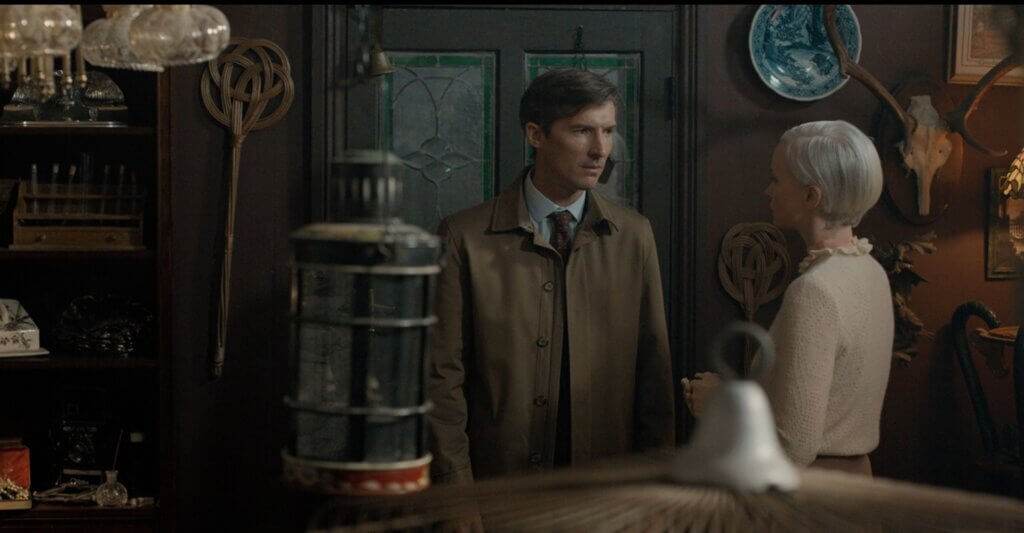 Ted speaks with Darcy among the strange antiques in her curiosity shop in Oddity