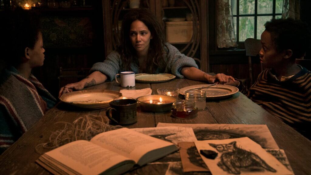 Momma holds Nolan and Samuel’s hands across the candlelit dinner table in Never Let Go.