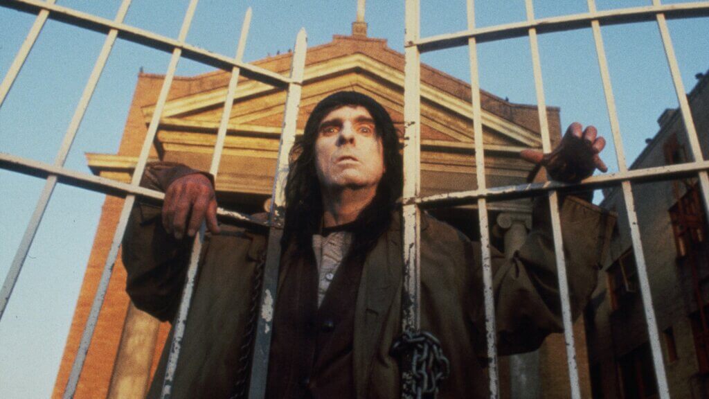 The homeless leader watches from the church gate in Prince of Darkness (1987)