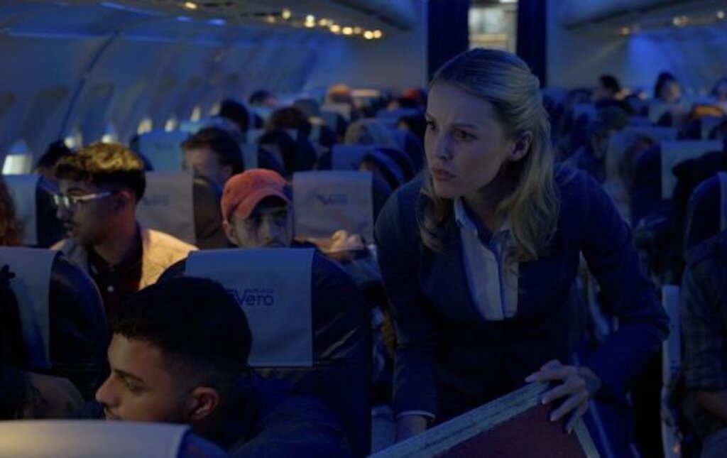 A flight attendant speaks to concerned passengers aboard Flight 298 in Black Box (2026).