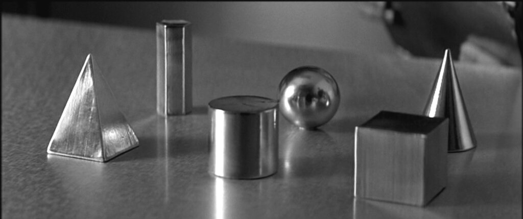 Metal objects are arranged for the conditioning experiment used to test Sammy Jankis’s memory in Memento (2000).