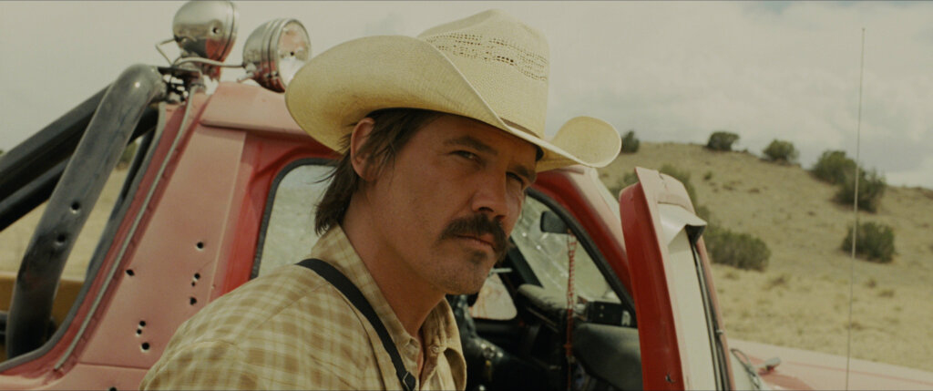 No_Country_for_Old_Men_02_Moss_at_Desert_Crime_Scene.jpg Llewelyn Moss stands beside his truck after discovering the desert crime scene.