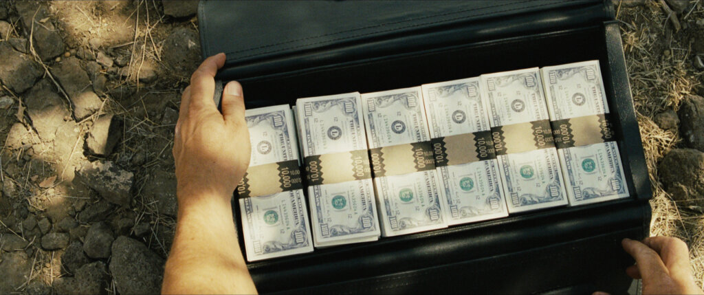 No_Country_for_Old_Men_04_Briefcase_of_Money.jpg Hands hold open the briefcase of cash found in the desert.