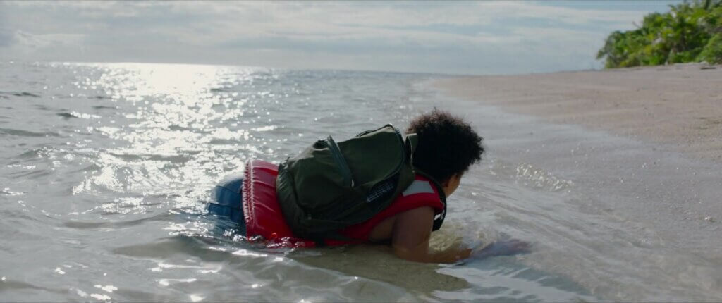 Jenn lies in shallow water on the island beach after the shipwreck in Sweetheart (2019).