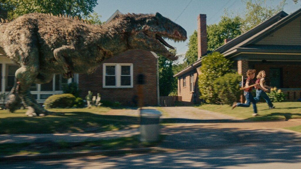 A feathered dinosaur chases the Platt family past a suburban brick house in The End of Oak Street.