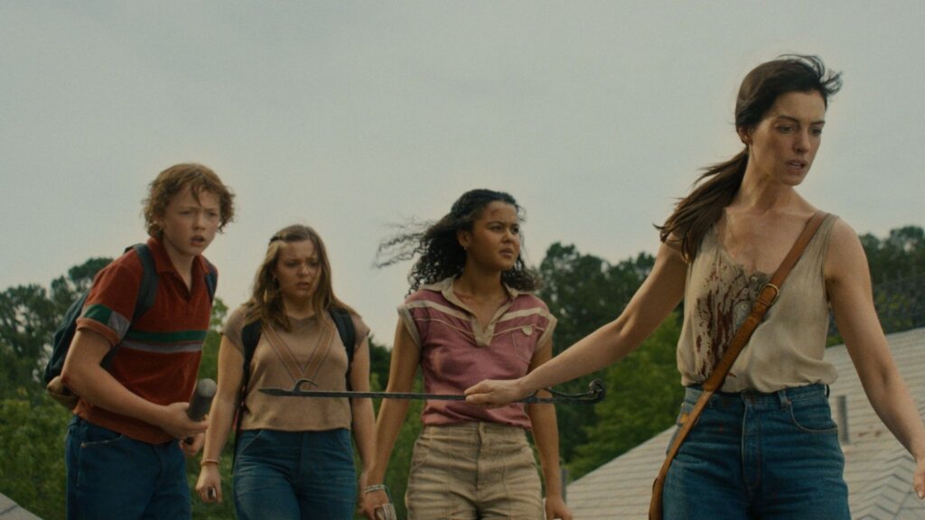 Denise leads Audrey, Brian, and another young survivor through the transformed landscape in The End of Oak Street.