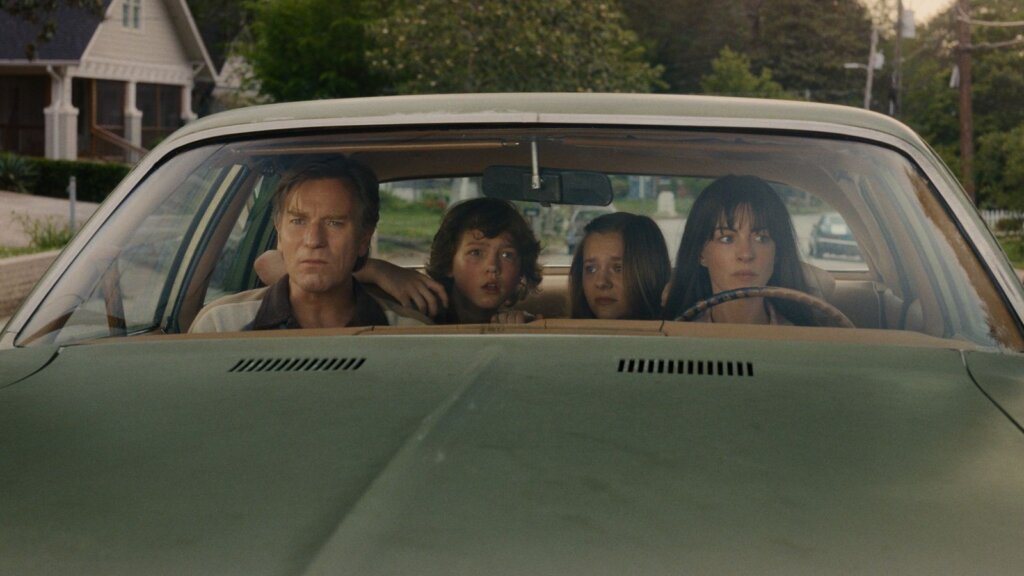 The frightened Platt family crowds inside their green car while facing danger in The End of Oak Street.