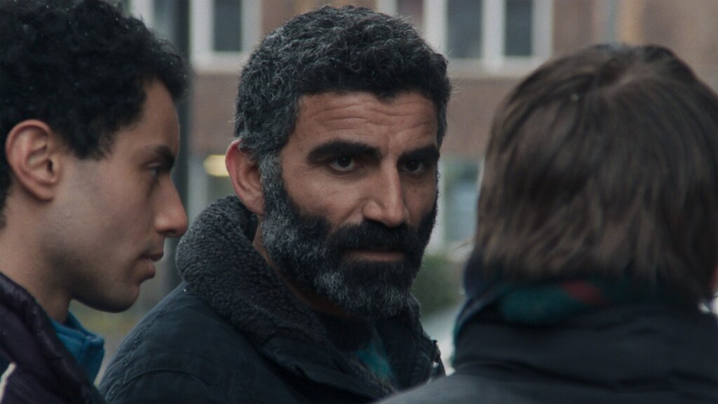 Mustafa faces Elif as Said stands beside him in Hysteria (2025).