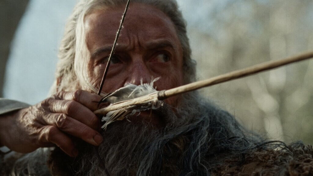 Hugh Jackman’s aging Robin Hood draws an arrow, his face framed tightly behind the bow.