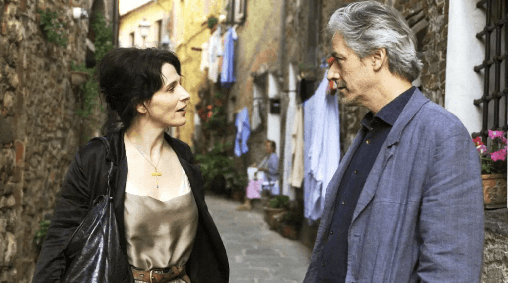 A woman and a writer walk through a Tuscan street in Certified Copy.