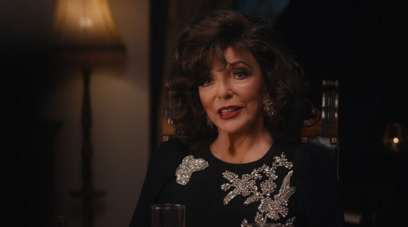 Francesca Carlyle (Joan Collins) sits in an ornate chair wearing a black outfit with sparkling brooches in A Murder Between Friends (2026).