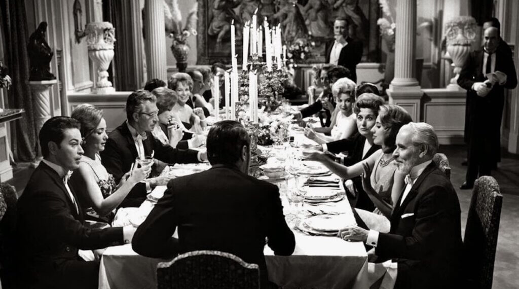 Dinner guests gather at a formal table in The Exterminating Angel.